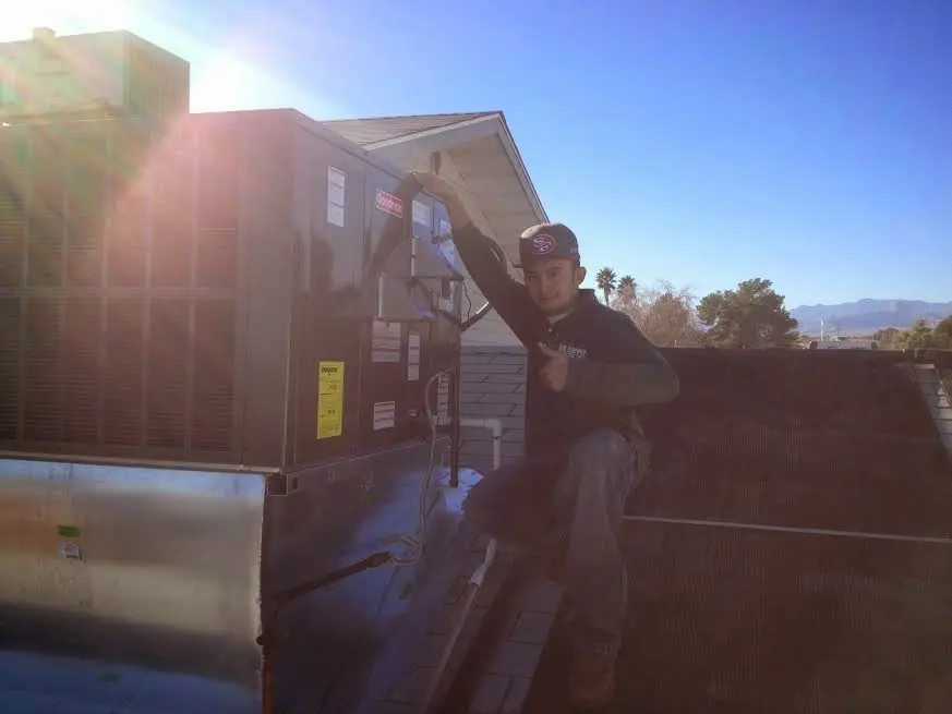 HVAC technician performing Air Duct Repair on a rooftop unit in Saratoga Springs